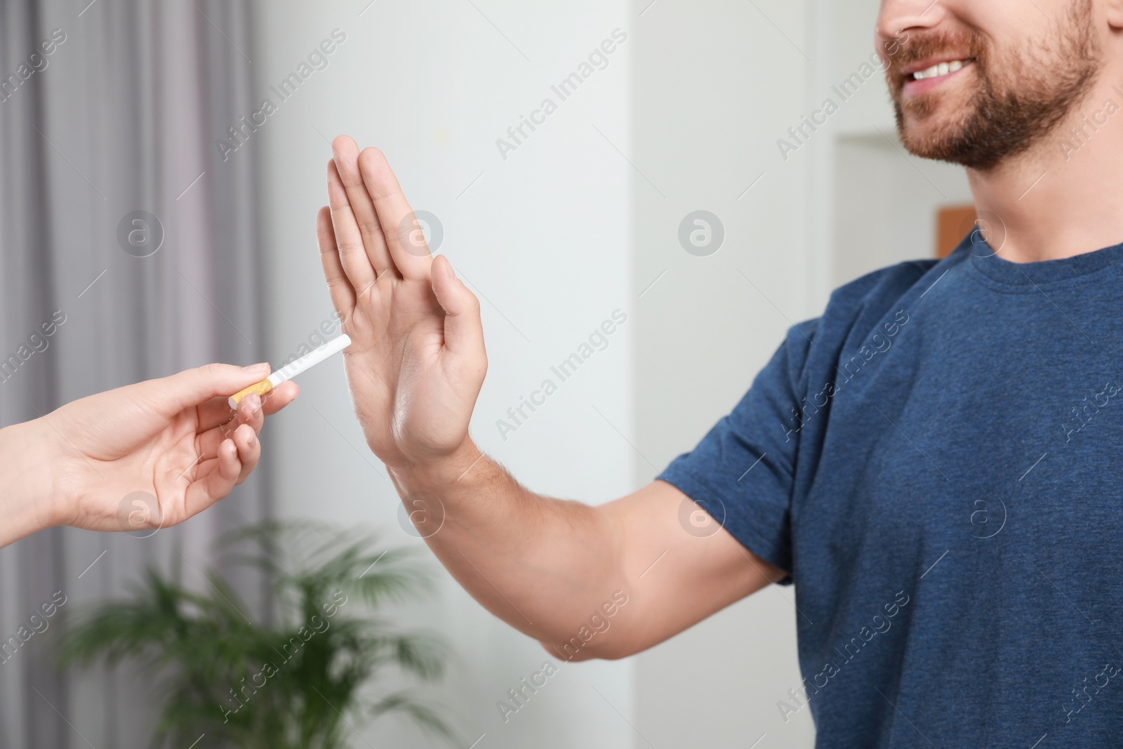 Photo of Man refusing cigarette at home, closeup. Quitting smoking concept