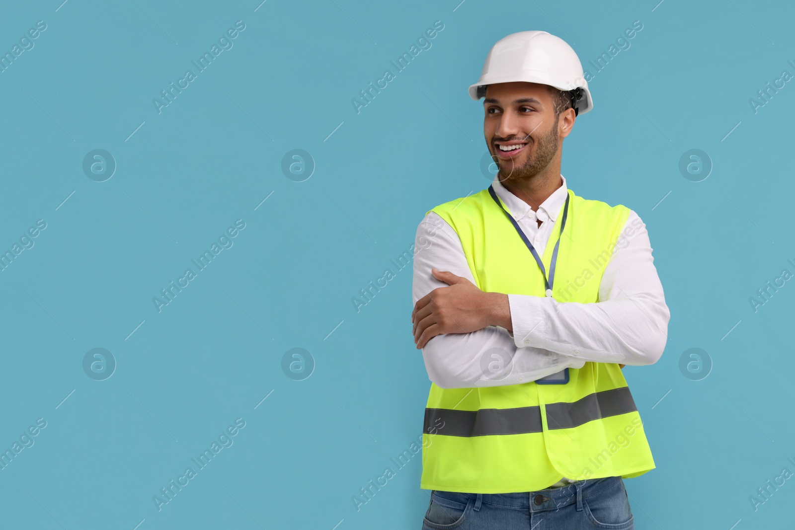 Photo of Engineer in hard hat on light blue background, space for text