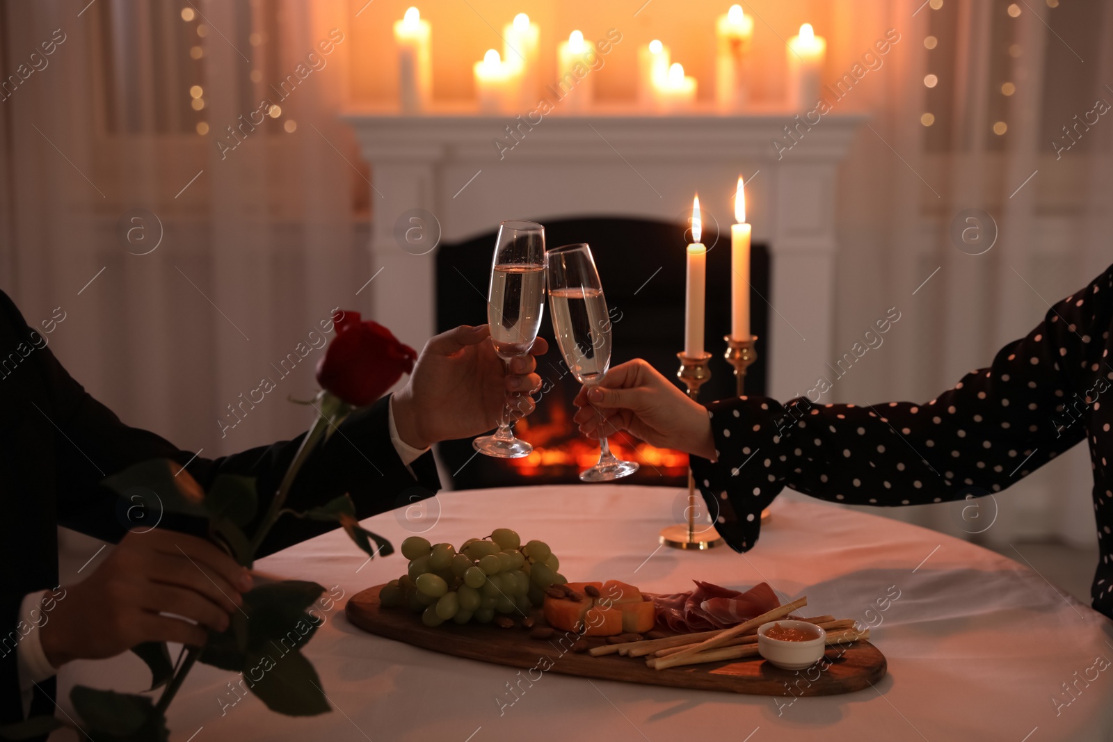 Photo of Couple clinking glasses of champagne in restaurant, closeup. Romantic dinner