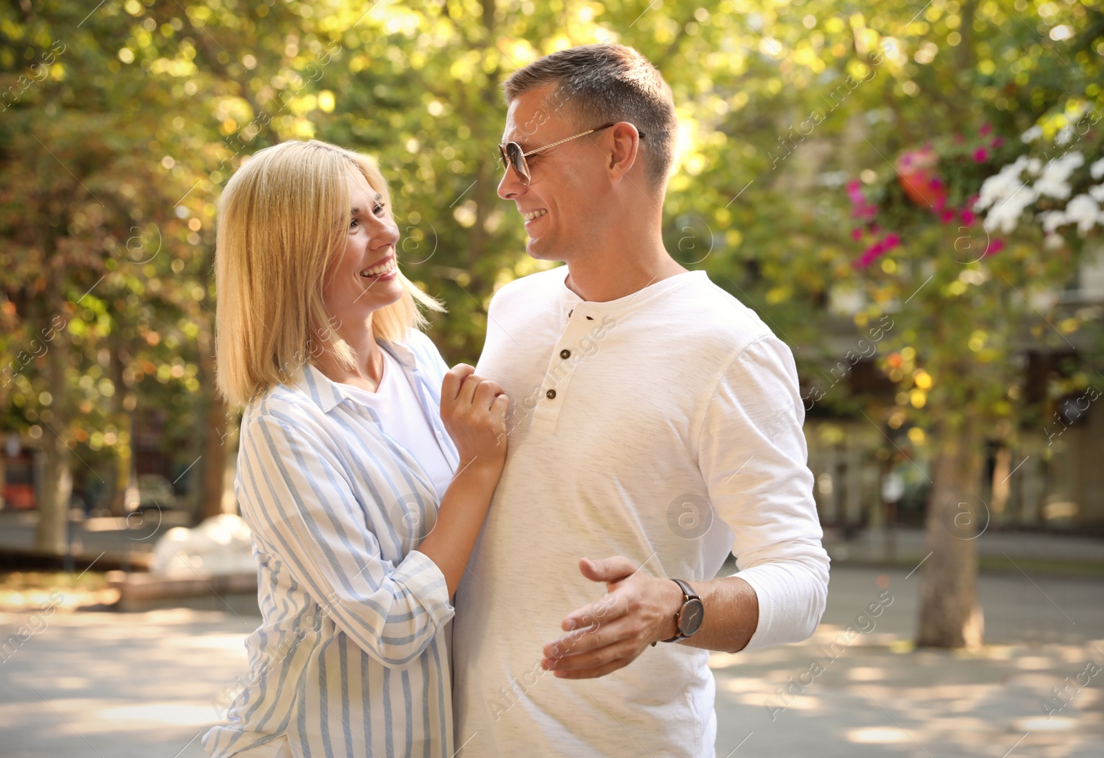 Photo of Happy couple walking along park on summer day