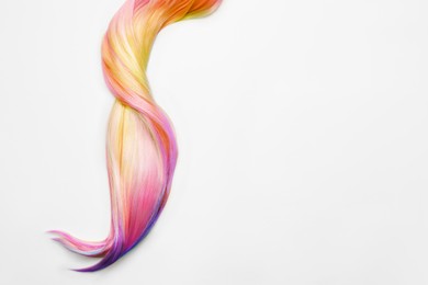 Strand of beautiful multicolored hair on white background, top view