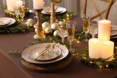 Photo of Christmas table setting with burning candles and festive decor