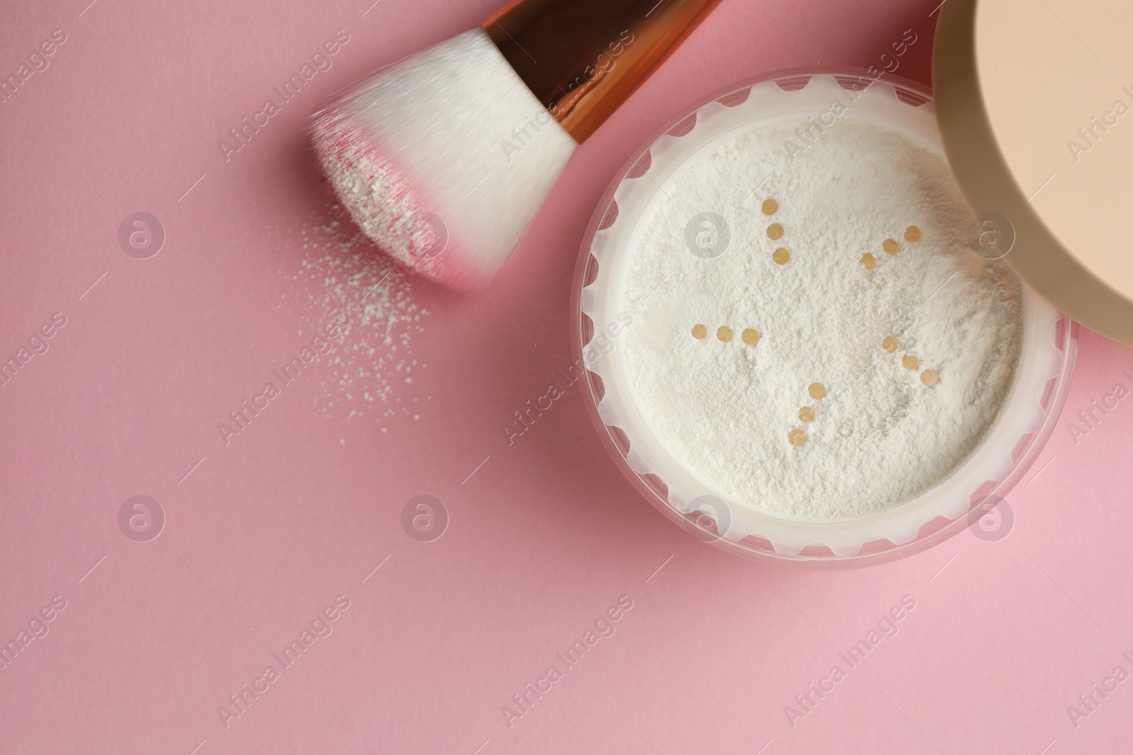 Photo of Rice loose face powder and makeup brush on pink background, flat lay. Space for text
