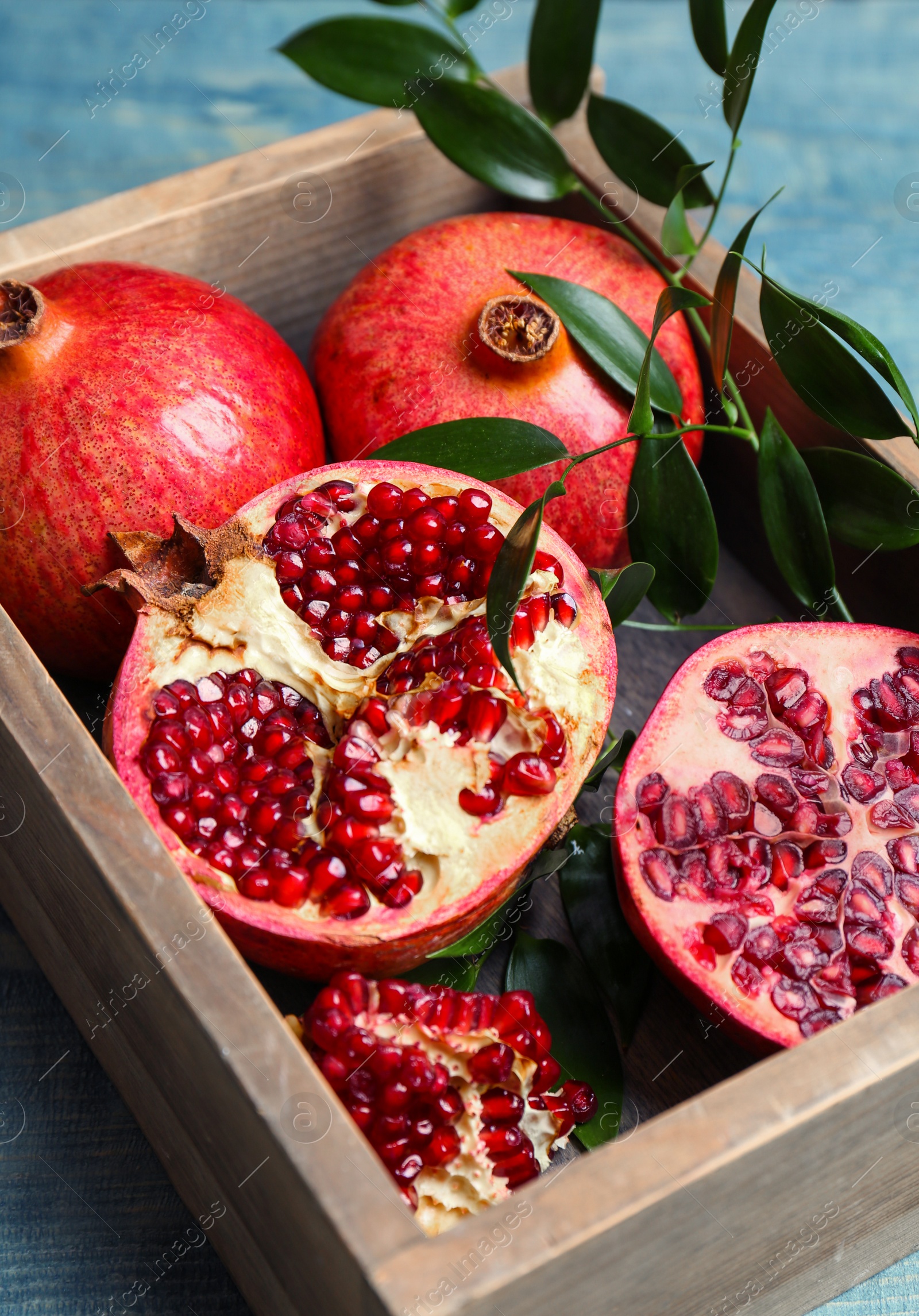 Photo of Box with pomegranates on wooden table