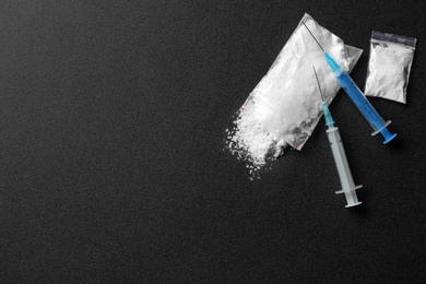 Photo of Flat lay composition with cocaine and syringes on dark background. Space for text