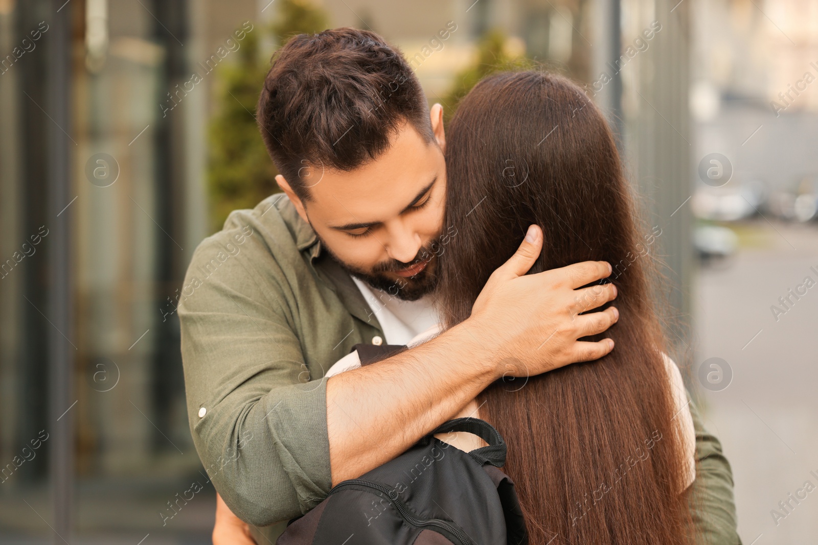 Photo of Long-distance relationship. Young couple with backpack hugging outdoors