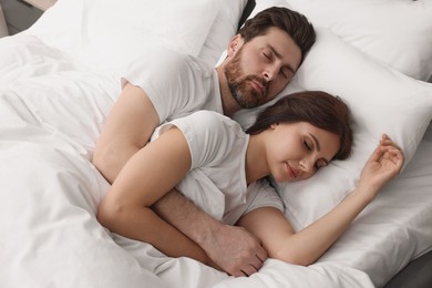 Lovely couple sleeping together in bed at home