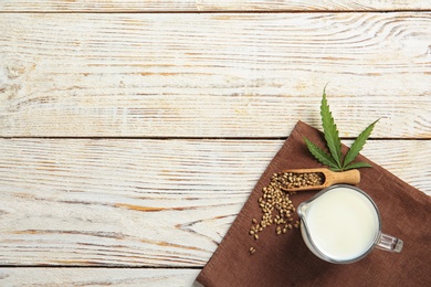 Flat lay composition with hemp seeds, milk and space for text on wooden background