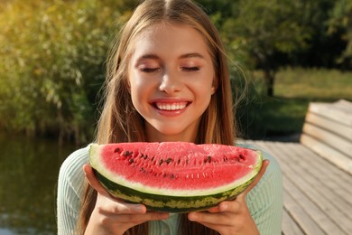 Beautiful girl with slice of watermelon outdoors