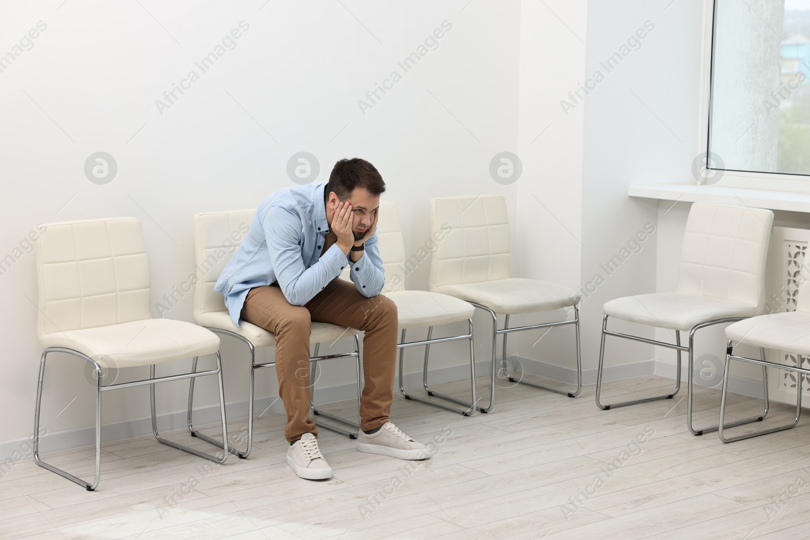 Photo of Man sitting on chair and waiting for job interview indoors