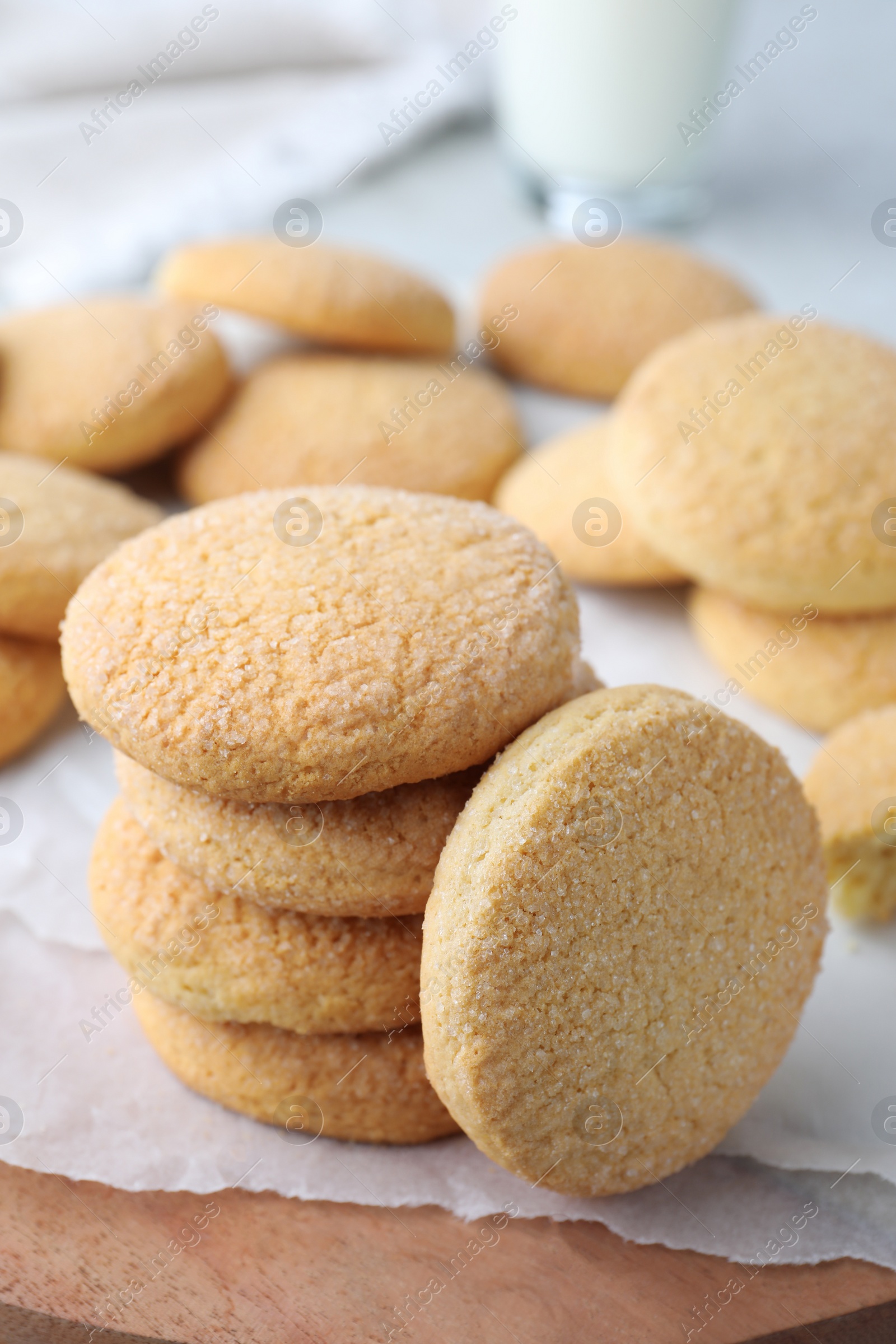 Photo of Many tasty sugar cookies on wooden board, closeup