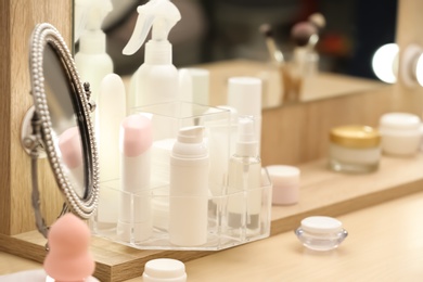 Photo of Organizer with cosmetic products on dressing table indoors