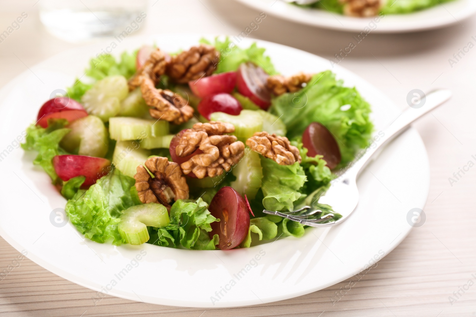 Photo of Delicious fresh celery salad on white wooden table, closeup