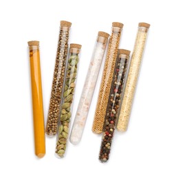 Glass tubes with different spices on white background, top view