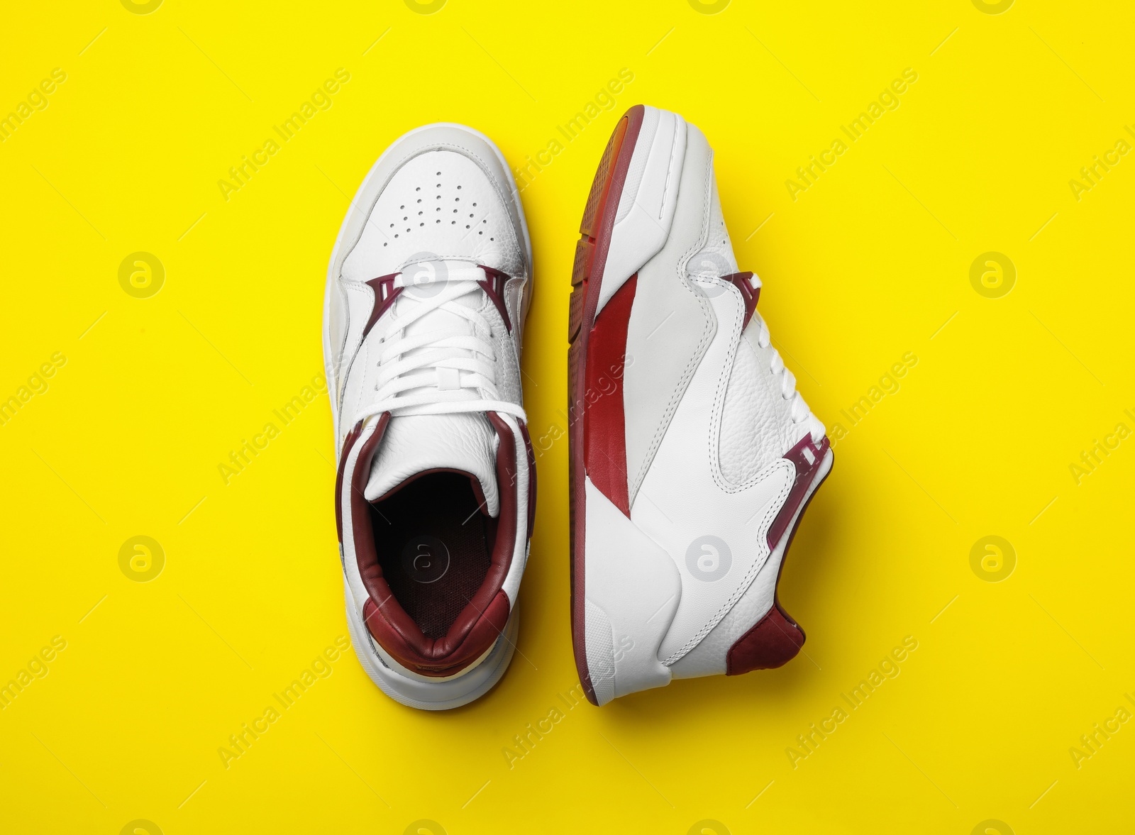 Photo of Pair of stylish shoes on yellow background, top view