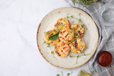 Photo of Freshly baked bacon and egg muffins with cheese served on white marble table, flat lay. Space for text