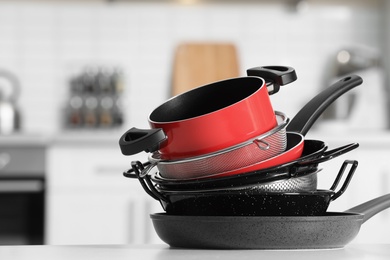 Set of clean cookware on table in kitchen. Space for text