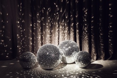 Photo of Many shiny disco balls in dark room