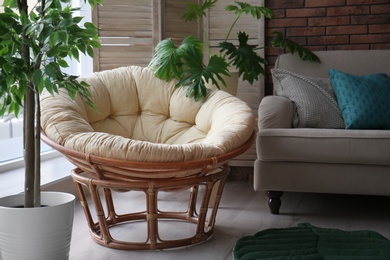 Photo of Cozy apartment with lounge round chair near window. Type of armchair for interior design