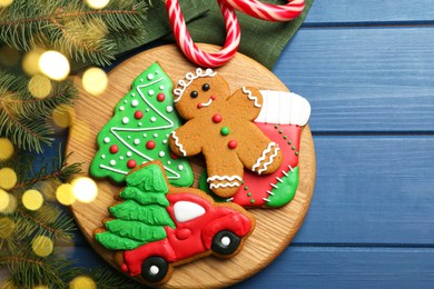 Different tasty Christmas cookies and decor on blue wooden table, flat lay. Space for text