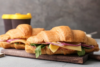 Photo of Tasty croissant sandwiches with salami on table