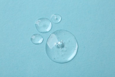 Photo of Samples of cosmetic serum on light blue background, flat lay