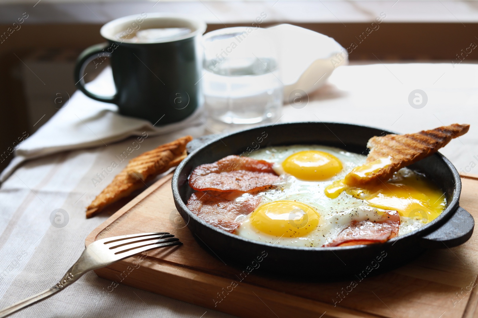 Photo of Tasty fried eggs with bacon and toast on table, space for text