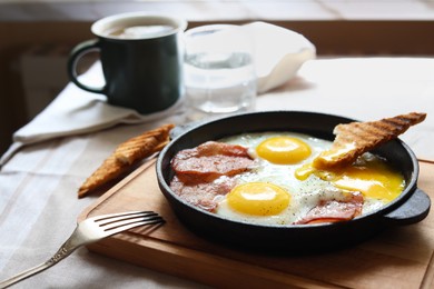 Tasty fried eggs with bacon and toast on table, space for text