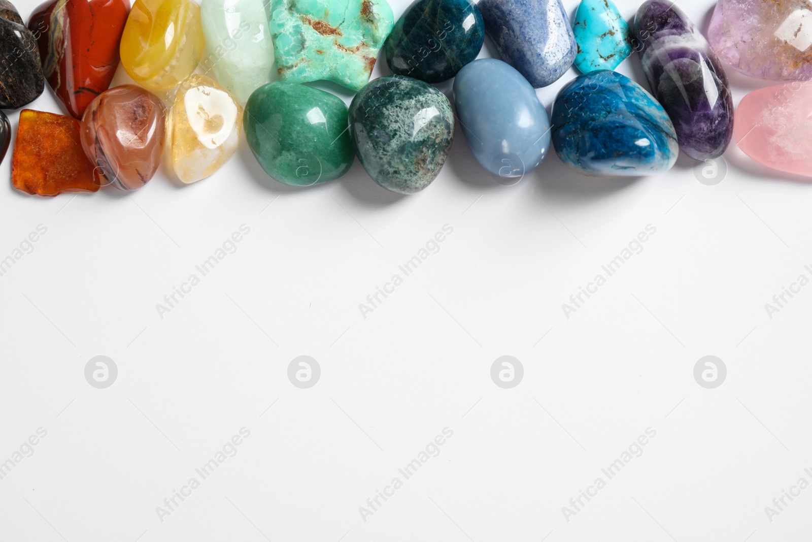 Photo of Different beautiful gemstones on white background, top view