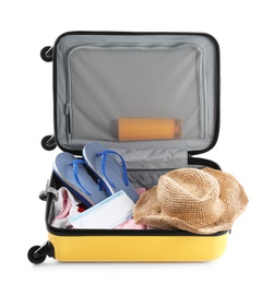 Packed suitcase with summer clothes and accessories on white background