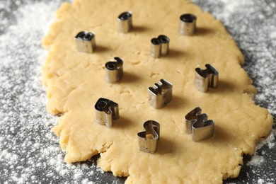 Making shortcrust pastry. Raw dough and cookie cutters on grey table