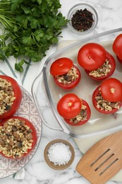 Photo of Delicious stuffed tomatoes with minced beef, bulgur and mushrooms in glass baking dish on white table, flat lay
