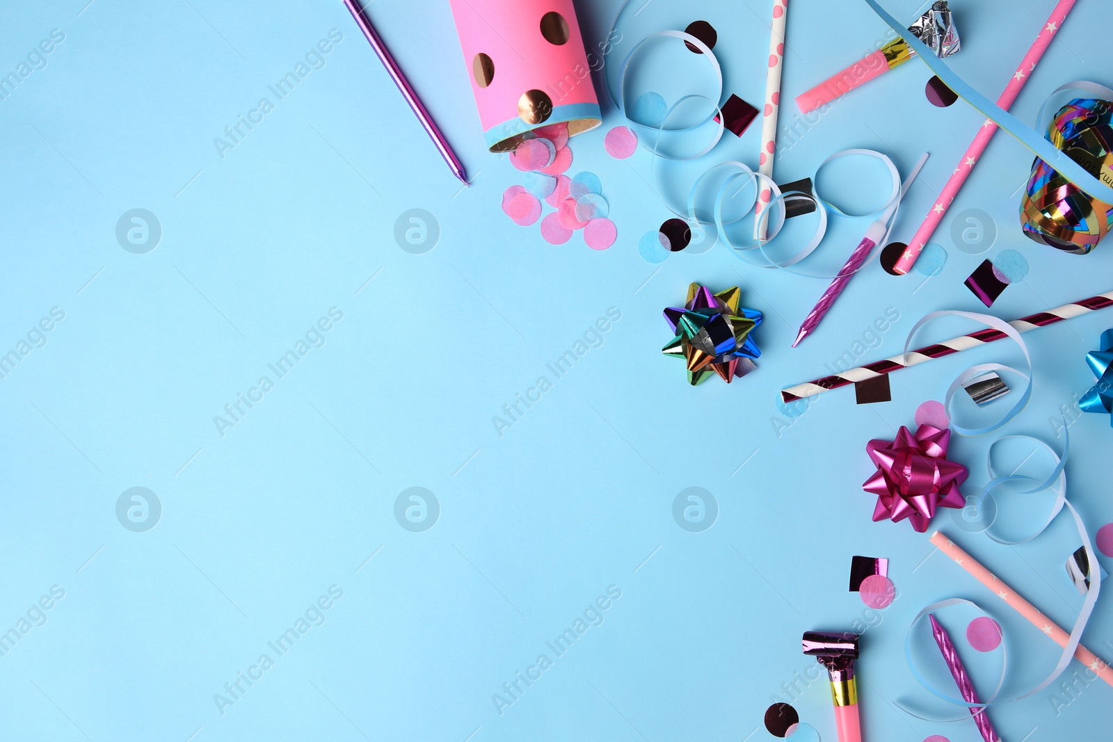 Photo of Party popper with confetti, blower and festive decor on light blue background, flat lay. Space for text