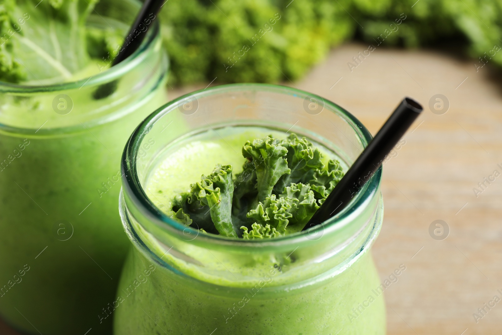 Photo of Tasty fresh kale smoothie on table, closeup