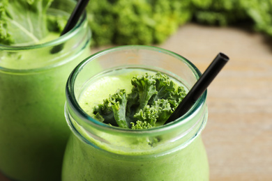 Photo of Tasty fresh kale smoothie on table, closeup