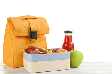 Lunch box with appetizing food and bag on table against white background