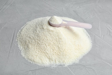 Photo of Pile of protein powder and scoop on grey background. Preparing shake