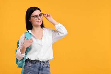 Photo of Smiling student in glasses on yellow background. Space for text