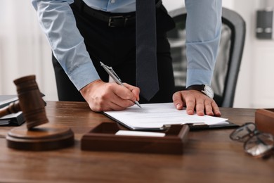 Photo of Lawyer working at wooden table in office, closeup