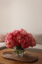 Beautiful pink peonies in vase on table at home, space for text. Interior design