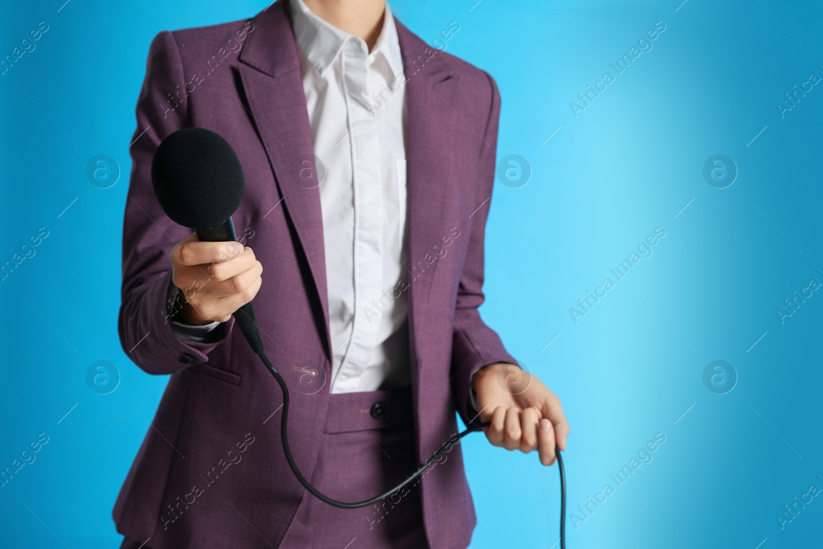 Photo of Professional journalist with microphone on light blue background, closeup. Space for text