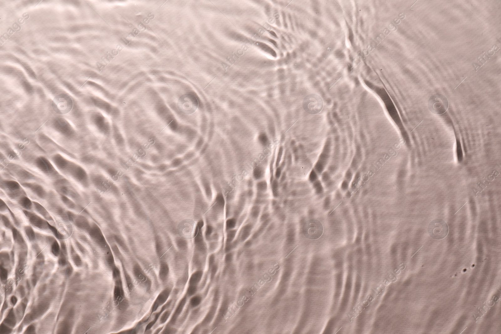 Photo of Rippled surface of clear water on beige background, top view