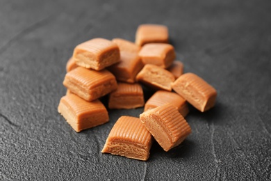 Delicious caramel candies on dark background