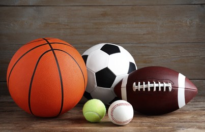 Photo of Set of different sport balls on wooden table