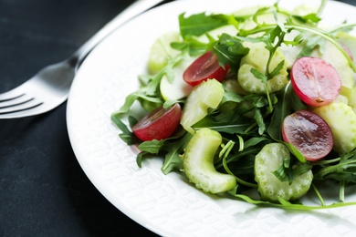 Photo of Delicious fresh celery salad on black table, closeup