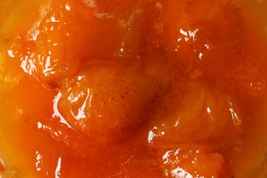 Photo of Delicious apricot jam as background, closeup view