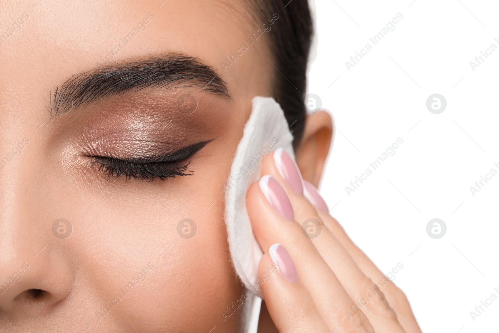 Photo of Beautiful woman removing makeup with cotton pad on white background, closeup