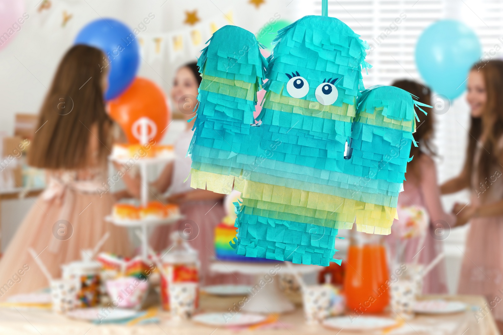 Image of Bright festive pinata hanging indoors at birthday party