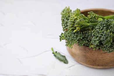 Photo of Bowl with fresh raw broccolini on white table, closeup and space for text. Healthy food