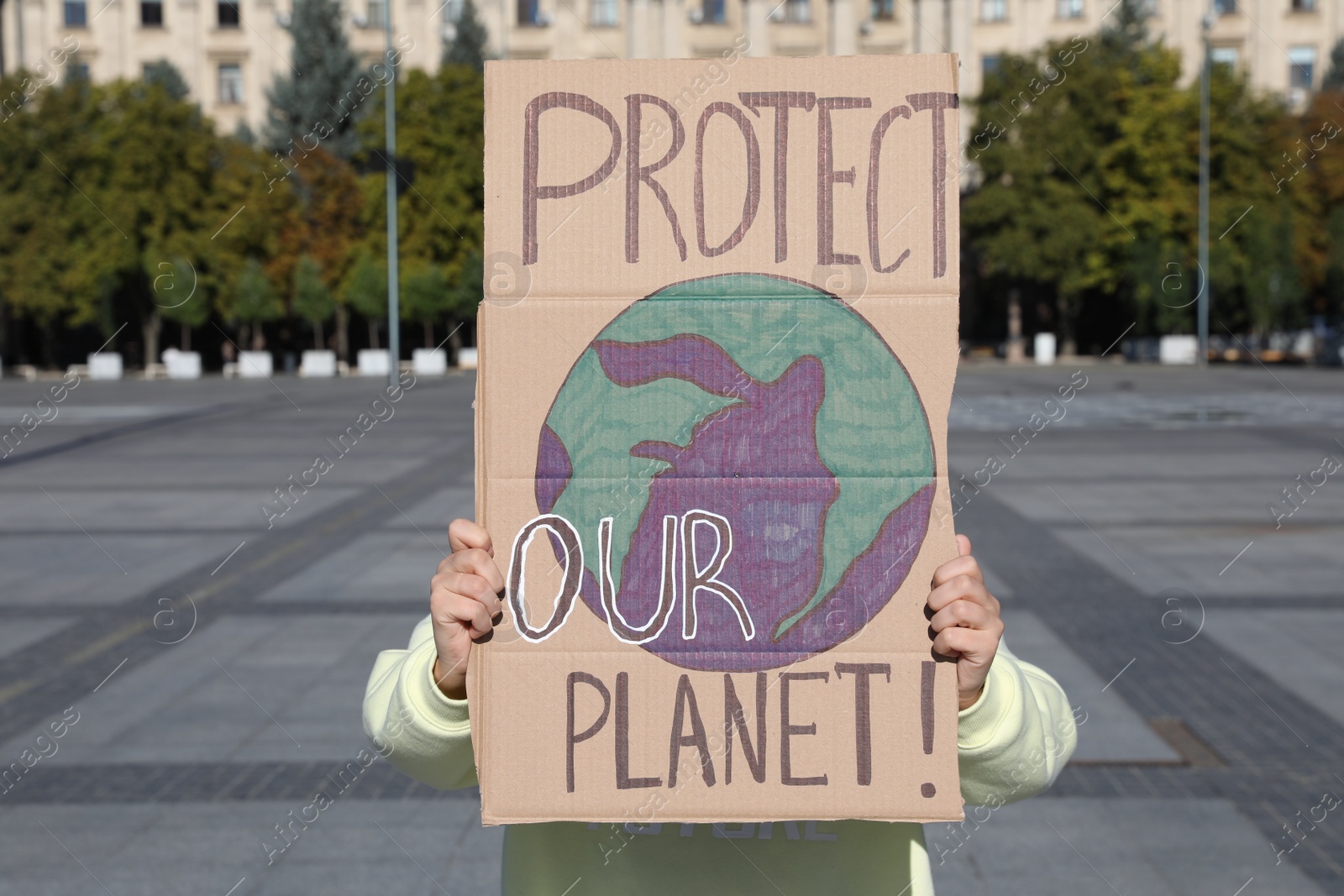 Photo of Woman with poster protesting against climate change on city street